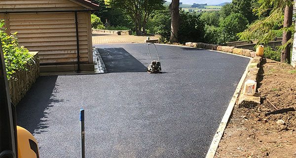 a tarmac driveway leading up to a house