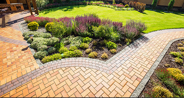 a landscaped garden with a block-paved path through the garden