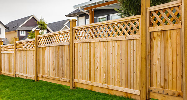 a wooden lattice fence erected to separate two hopes 