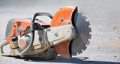 a handheld steel saw on the ground